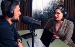 Business professionals recording a B2B podcast interview in a modern office studio setting. Photo by Unsplash