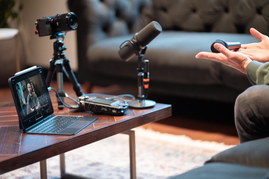 Professional podcast production setup with camera, microphone, and laptop for video and audio recording